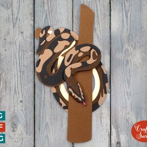 May include: A brown and black snake wrapped around a brown wooden branch. The snake has a light brown and black pattern. The snake is curled up and its head is facing the viewer. The snake is on a wooden background.