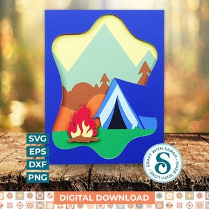 Puede incluir: Una pieza de arte en papel en capas con temática de camping. El diseño presenta un fondo azul con una cordillera, una tienda de campaña y una fogata. Las palabras "SVG, EPS, DXF, PNG" están a la izquierda y "DESCARGA DIGITAL" en la parte inferior.