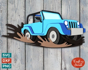 May include: A blue jeep driving through brown mud with tire tracks. The jeep has a black top and black wheels. The background is a wooden surface.