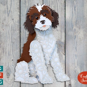 May include: A white and brown papercraft dog with intricate floral designs. The dog is sitting with its head tilted and its tongue sticking out.