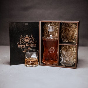 May include: A wooden gift box with a personalized decanter and two glasses. The box is engraved with "Happy 25th Birthday" and the initial "S".