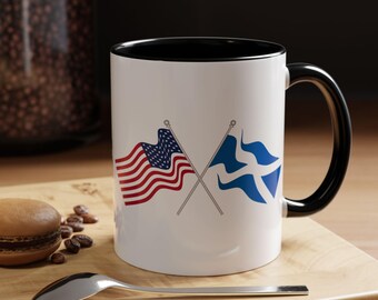 May include: White ceramic mug with a black rim and handle. The mug features a crossed American and Scottish flag design.