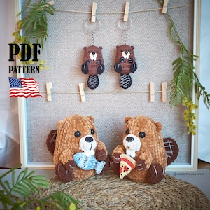 May include: Crocheted beaver keychains and plush toys. The plush beavers are brown with white accents, holding a blue fish and a pizza slice. The keychains are smaller versions of the plush toys. The image includes the text "PDF PATTERN" and an American flag.