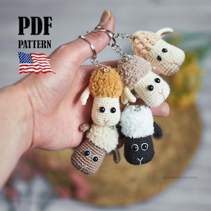 Könnte beinhalten: Eine Sammlung handgefertigter Häkelschaf-Schlüsselanhänger in verschiedenen Farben, darunter Braun, Beige und Schwarz. Jeder Schlüsselanhänger zeigt ein Schafdesign mit flauschigem Kopf und kleinen, runden Augen. Das Bild enthält den Text "PDF PATTERN" und eine US-Flagge.
