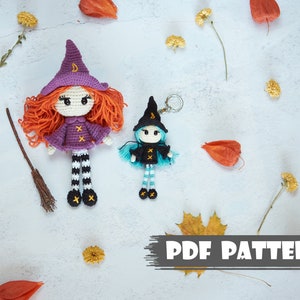 May include: Two crocheted witch dolls, one larger with orange hair and a purple dress, the other smaller with blue hair and a blue dress. Both dolls are wearing black and white striped stockings and black shoes. The dolls are on a white background with autumn leaves and flowers. The text "PDF PATTERN" is at the bottom of the image.