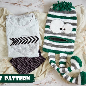 Puede incluir: Un patrón de crochet para un monstruo de rayas verdes y blancas con piernas largas. El patrón incluye instrucciones para tejer al crochet la cabeza, el cuerpo y las piernas del monstruo. El patrón está disponible para descargar en PDF.