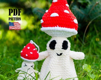 May include: A pair of crocheted mushroom figures, one large and one small, with red and white caps and white bodies. The larger mushroom figure has black eyes and a smiling mouth. The image includes the text "PDF PATTERN" and an American flag.