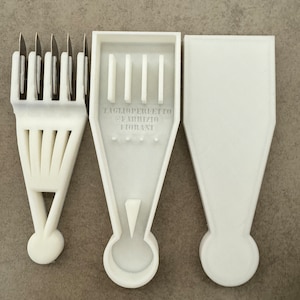 Könnte beinhalten: Dreiteiliges weißes Küchenwerkzeug-Set. Das erste Teil hat mehrere Klingen. Das zweite Teil trägt den Text "TAGLIOPERFETTO @FABRIZIO FIORANI". Das dritte Teil ist eine feste Abdeckung. Die Werkzeuge sind aus weißem Kunststoff.