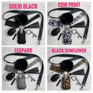 May include: Four different styles of hand sanitizer holders with a black pom-pom, black tassel, and a key chain with a small alarm and a bottle opener. The styles are solid black, cow print, leopard print, and black sunflower.