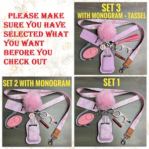 May include: Three sets of pink and white patterned lanyard keychains with a pink fuzzy pom-pom charm. Each set includes a pink hand sanitizer holder, a personal alarm, a bottle opener, and a whistle. The text on the image reads "PLEASE MAKE SURE YOU HAVE SELECTED WHAT YOU WANT BEFORE YOU CHECK OUT", "SET 3 WITH MONOGRAM + TASSEL", "SET 2 WITH MONOGRAM", and "SET 1".