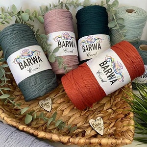 Könnte beinhalten: Sortiment an bunten Baumwollschnüren in einem Weidenkorb. Die Schnüre sind mit "Barwa Cord" beschriftet und in Grün, Rosa, Orange und Blau erhältlich.