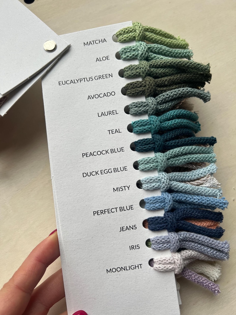 Op de afbeelding: Een kleurenkaart met 14 verschillende tinten garen, waaronder matcha, alo&euml;, eucalyptusgroen, avocado, laurier, teal, pauwblauw, eendeneiblauw, mistig, perfect blauw, jeans, iris en maanlicht.