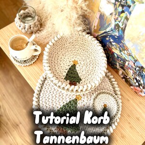Könnte beinhalten: Handgefertigte Häkelartikel in Off-White, darunter Untersetzer, ein Platzset und ein kleiner Teller, alle mit einem Weihnachtsbaum-Design. Der Text "Tutorial Korb Tannenbaum" ist sichtbar. Eine Tasse Kaffee steht auf einem Untersetzer.