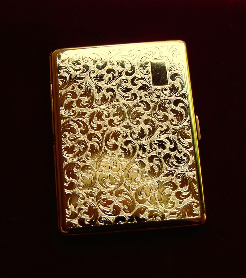 Peut inclure: Un &eacute;tui &agrave; cigarettes en or avec un motif floral orn&eacute;.