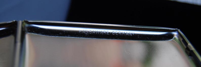 Peut inclure: Gros plan d'un objet en m&eacute;tal argent&eacute; avec l'inscription "HANSWARE - GERMANY" sur le c&ocirc;t&eacute;.