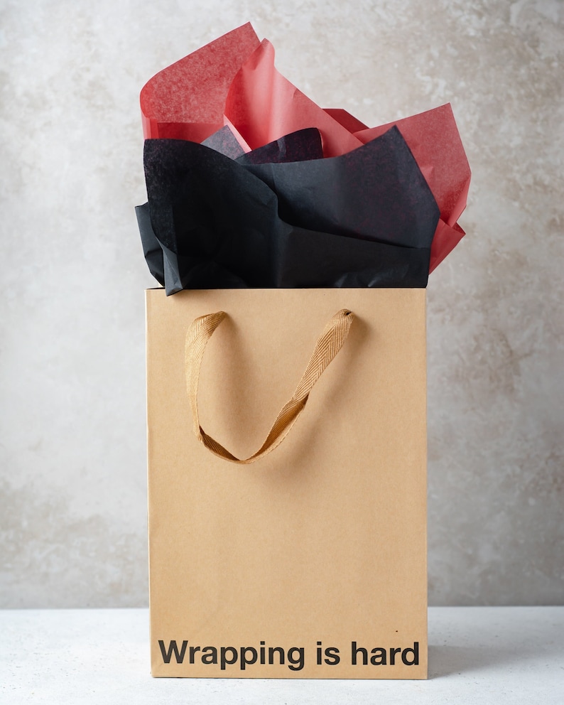 A funny gift bag made from eco-friendly brown kraft paper with "wrapping is hard" written on the front