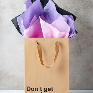 A funny gift bag made from eco-friendly brown kraft paper with "Don't get your hopes up" written on the front