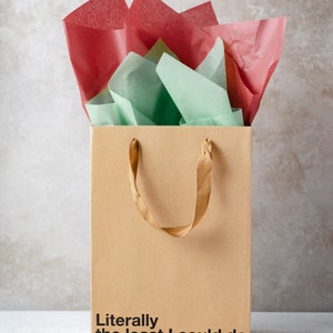 A funny gift bag made from eco-friendly brown kraft paper with "Literally the least I could do" written on the front