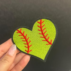 Peut inclure: Écusson brodé en forme de cœur, représentant un ballon de softball vert citron avec des coutures rouges et un bord noir. Le patch est conçu pour être repassé ou cousu sur du tissu.
