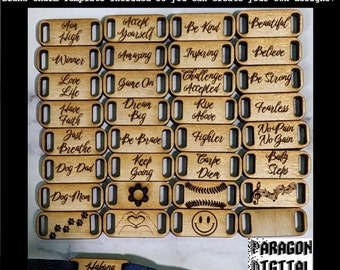 May include: A set of 20 wooden shoe charms with various inspirational phrases and designs. The charms are laser cut and engraved with sayings like "Aim High", "Accept Yourself", "Be Kind", "Beautiful", "Winner", "Amazing", "Inspiring", "Believe", "Love Life", "Game On", "Challenge Accepted", "Be Strong", "Have Faith", "Dream Big", "Rise Above", "Fearless", "Just Breathe", "Be Brave", "Fighter", "No Pain No Gain", "Dog Dad", "Keep Going", "Carpe Diem", "Baby Steps", "Dog Mom", "Hakuna Matata".