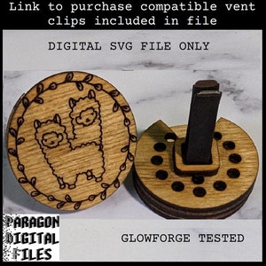 Könnte beinhalten: Eine digitale SVG-Datei mit dem Design von zwei Alpakas mit einem Blumengirlanden um sie herum. Das Design ist lasergeschnitten auf einem runden Holzstück. Das Bild zeigt auch einen Holz-Lüftungsclip mit einem schwarzen Lüftungsclip-Einsatz. Der Text "DIGITAL SVG FILE ONLY" und "GLOWFORGE TESTED" ist auf dem Bild sichtbar.