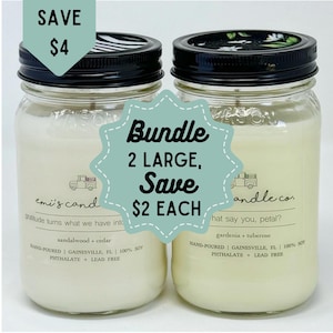May include: Two large glass candle jars with black lids. The jars are filled with white candle wax. The jars are labelled "emi's cand" and "andle.co.". The text "Bundle 2 LARGE, Save £2 EACH" is written on a green circle sticker.