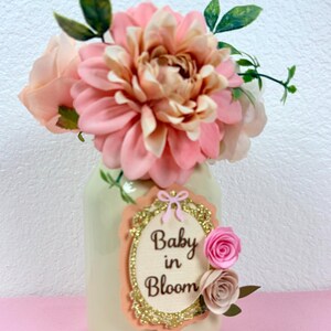 baby in bloom floral mason jar centerpiece on pink background with soft pastel baby shower theme