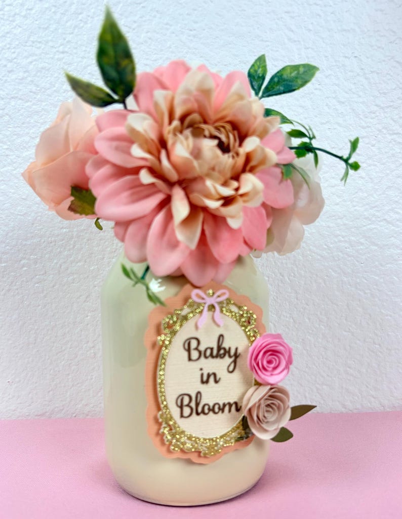 baby in bloom floral mason jar centerpiece on pink background with soft pastel baby shower theme