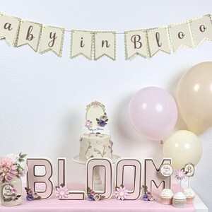baby in bloom baby shower table setup with matching banner and decorations in pink floral theme