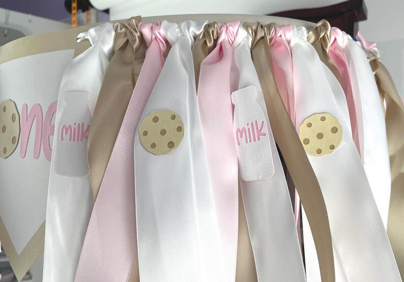 Close-up of milk and cookies highchair banner showing cardstock pieces and ribbon