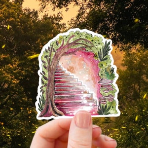 May include: A sticker featuring a watercolor illustration of a whimsical archway with stairs leading to a glowing light. The arch is framed by a tree and foliage, with a pink and red color scheme. The sticker is held in a hand against a blurred forest background.