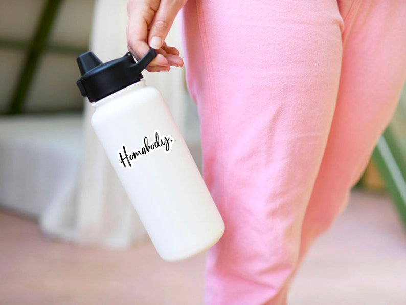 Pu&ograve; includere: Bottiglia d'acqua bianca con tappo nero e scritta nera "Homebody."