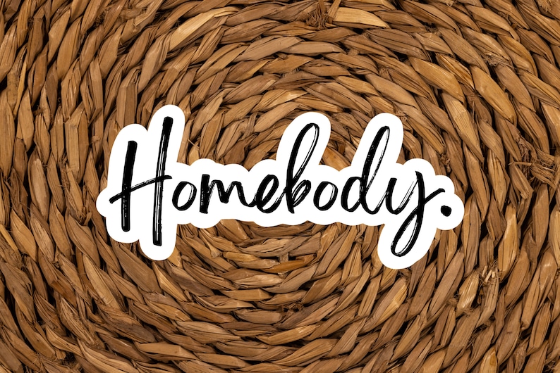 Pu&ograve; includere: La parola "Homebody" scritta in corsivo nero su uno sfondo bianco, con uno sfondo in vimini intrecciato marrone.
