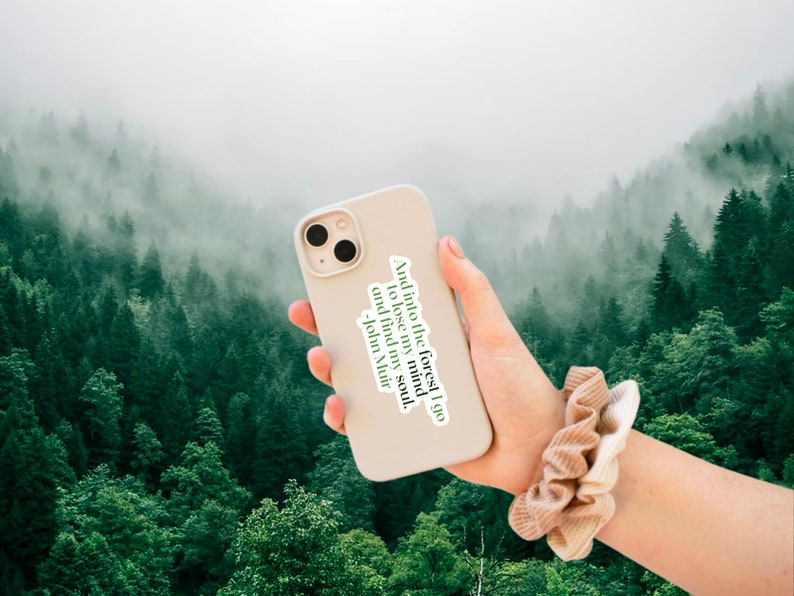 May include: A white iPhone case with a quote from John Muir: "And into the forest I go to lose my mind and find my soul."