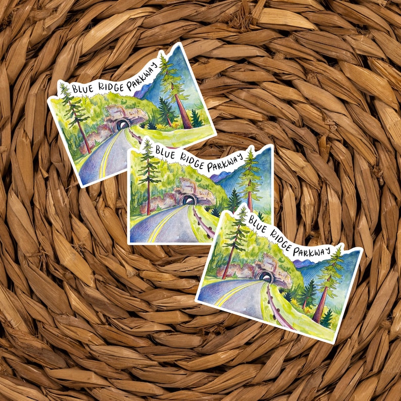 May include: Three watercolor stickers featuring a scenic view of the Blue Ridge Parkway. Each sticker features a winding road leading to a tunnel with lush green trees and a blue sky in the background. The text "Blue Ridge Parkway" is written in black cursive on each sticker.