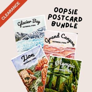 Puede incluir: Un conjunto de cuatro postales de acuarela con escenas de parques nacionales. Las postales incluyen Glacier Bay, Grand Canyon, Zion y Olympic National Park. El texto "OOPSIE POSTCARD BUNDLE" está en negro. Una pancarta roja "CLEARANCE" está en la esquina superior izquierda.