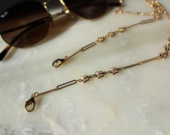 May include: Gold-toned glasses chain with butterfly-shaped charms and lobster claw clasps.