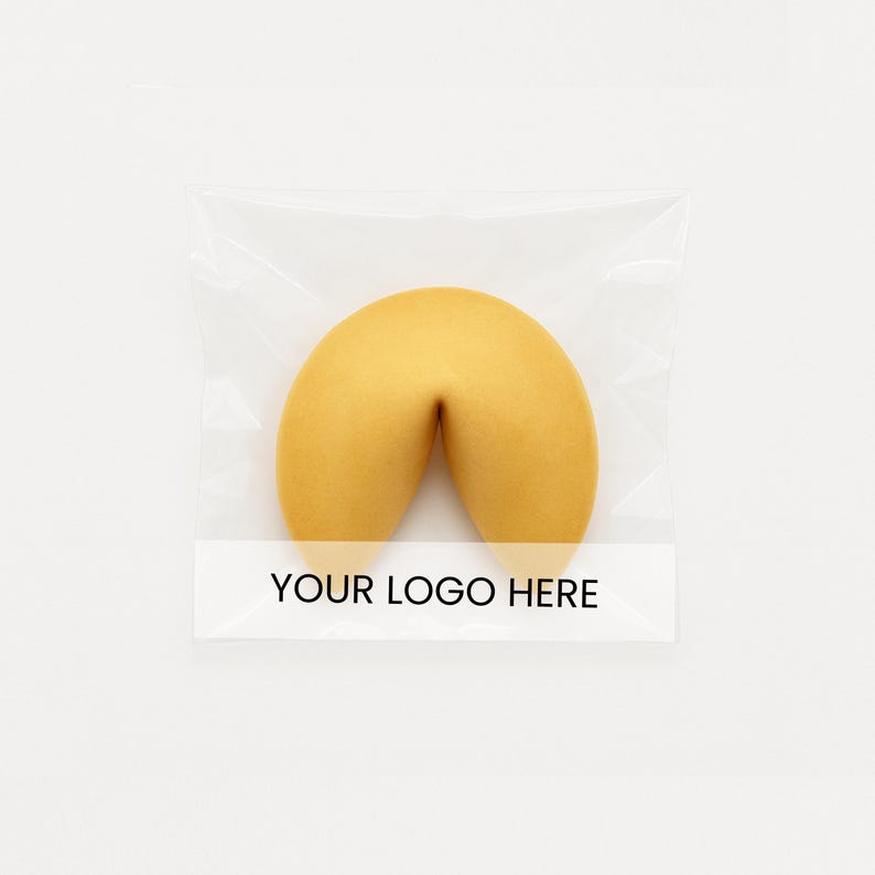 May include: A golden-brown fortune cookie in a clear plastic wrapper. The cookie has a curved shape, and the wrapper has a white label with the text "YOUR LOGO HERE" in black.
