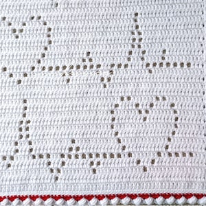 May include: White crochet blanket with a red border. The blanket has a repeating pattern of stars.