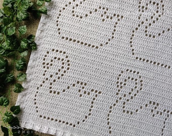 May include: A white crochet blanket featuring a repeating openwork pattern of hearts created with double crochet stitches. The textile has a textured surface with a consistent grid-like structure and a decorative border along the finished edge.