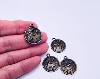 May include: Four bronze-colored clock charms with a vintage aesthetic. Each charm features a clock face with Roman numerals and ornate detailing. The charms have a loop at the top for attaching to jewelry or other crafts.