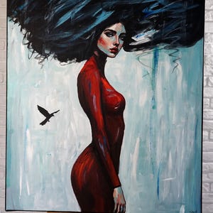 May include: An oil painting on canvas depicting a figure in a long-sleeved red dress with voluminous, dark, wind-swept hair. A small black bird is flying to the left against a light blue and white background with visible brushstrokes.