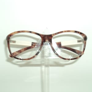 May include: Tortoise shell eyeglasses with clear lenses and a white bridge.