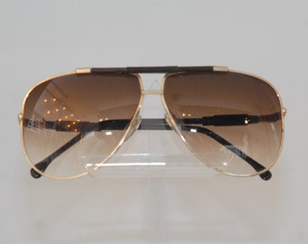 No name sunglasses, goldish metal with brown gradient lenses color, pilote form with confortable hold; Miami style