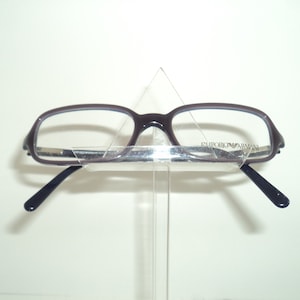 May include: Brown eyeglasses with black arms and the text "EMPORIO ARMANI" on the right arm.