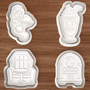 May include: Four white plastic cookie cutters featuring distinct shapes: a server holding a covered dish, a tall milkshake with a straw, an upholstered armchair, and a vintage-style jukebox. Each cutter has a raised edge for cutting dough.