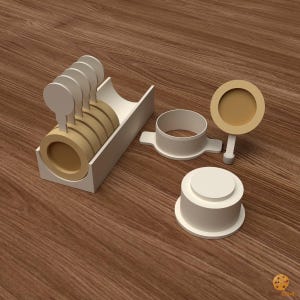 Peut inclure: Un ensemble d'outils à biscuits en plastique blanc et beige comprenant un support de rangement rectangulaire contenant cinq tampons circulaires, un emporte-pièce cylindrique avec poignées latérales, un tampon circulaire et une base.