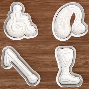 May include: A set of four white plastic cookie cutters featuring disability-related shapes: a wheelchair symbol, a behind-the-ear hearing aid, a white cane for the visually impaired, and a prosthetic leg. Each cutter has a raised edge for cutting.