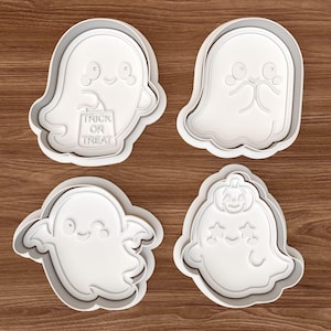 May include: Four white plastic ghost-shaped cookie cutters. One ghost holds a bag that says "Trick or Treat". The other three ghosts have different facial expressions and designs. Perfect for Halloween baking.