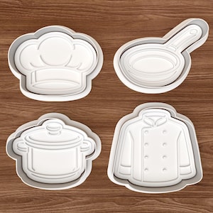 Op de afbeelding: Vier witte plastic koekjessnijders in de vorm van een koksmuts, een koekenpan, een pot en een koksjas. De uitstekers hebben een grijze omtrek en zijn gerangschikt op een bruin houten oppervlak.